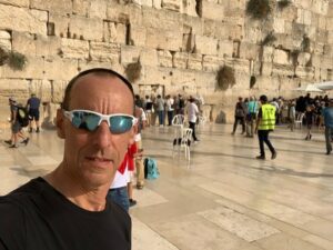A selfie of a man in Jerusalem with people in the background.