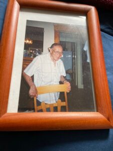 A framed photo of Samuel Zaritt holding a chair.