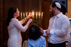 Rabbi Getzel Davis and his wife light the menorah at their wedding