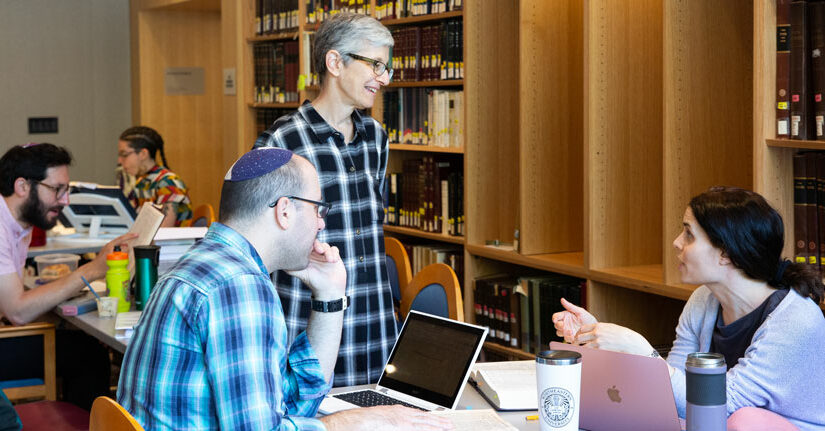 students and faculty member talking in beit midrash