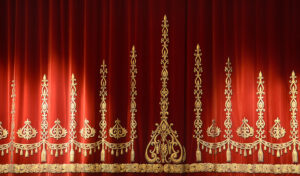 Red stage curtain with gold embroidery and fringe