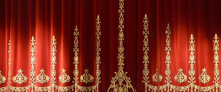Red stage curtain with gold embroidery and fringe