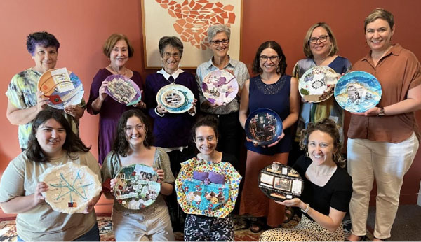 women holding up painted plates