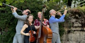 Photo of four-person band outside with their instruments